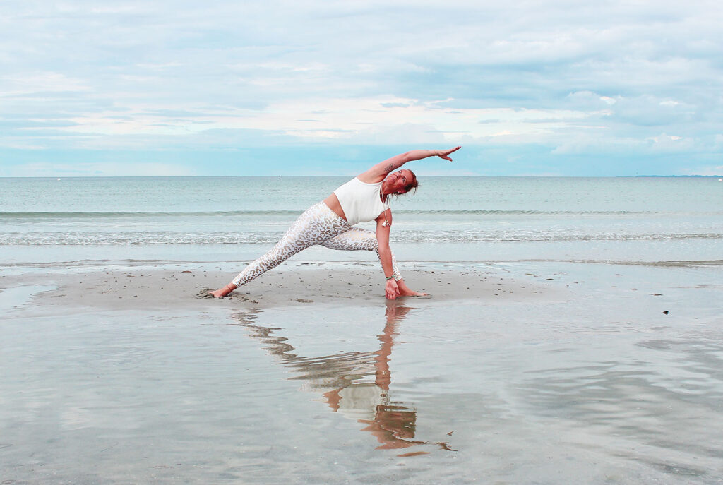 Strand Yoga an der Ostsee. Yogalehrerin mit Yogapose am Ostseeufer