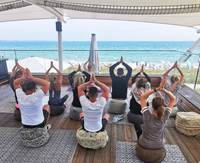 Firmen Yoga auf einer Aussichtsplattform mit Blick auf die Ostsee