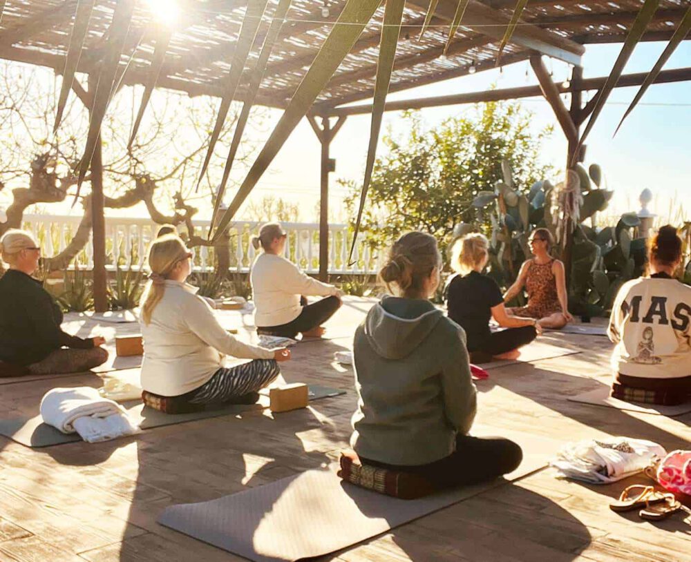 Yogagruppe im Lotussitz auf einer Terrasse