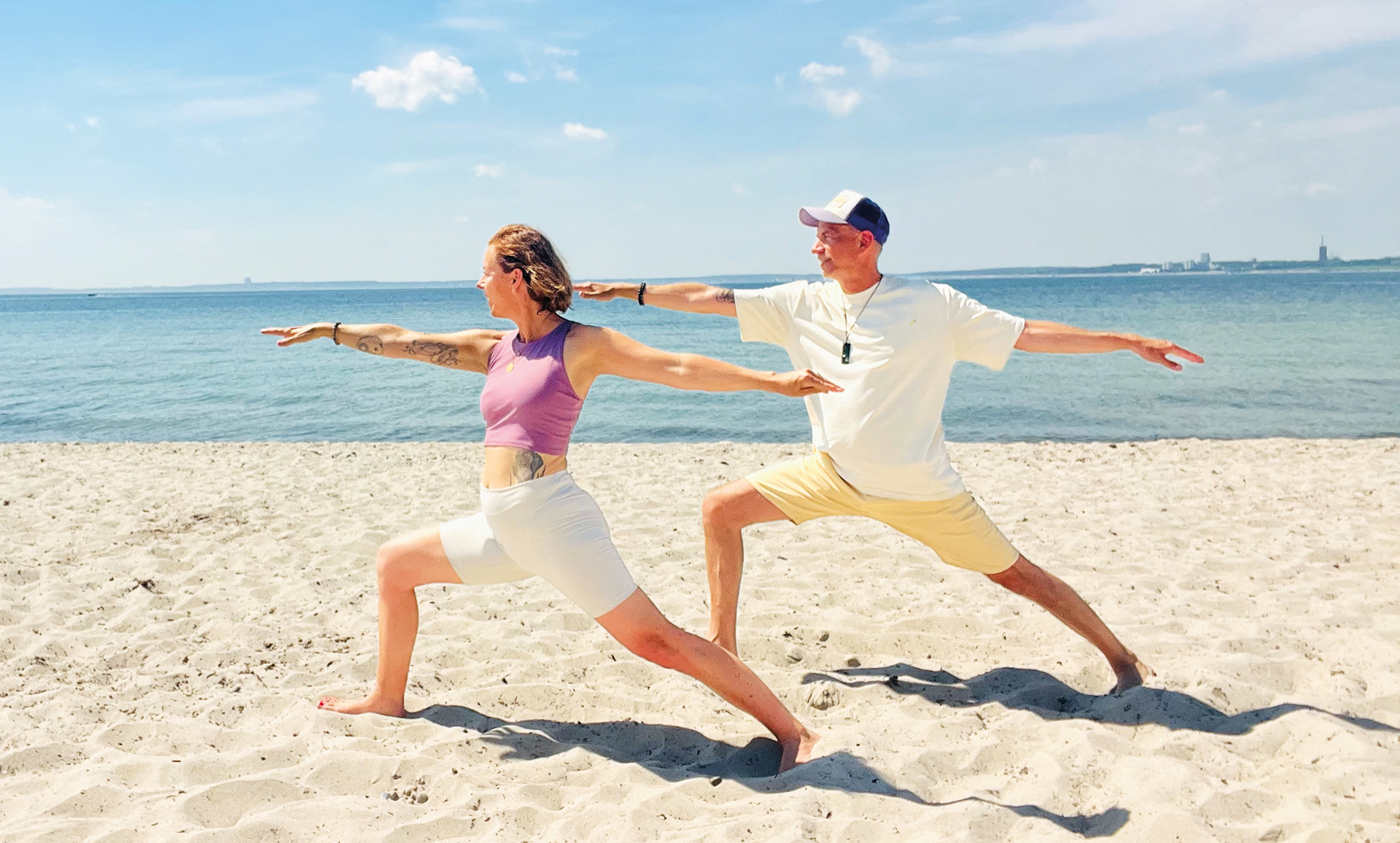 Yoga an der Ostsee: Die Krieger-Pose am Strand von Scharbeutz mit Yogacoast.