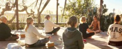 Yogagruppe im Lotussitz auf einer Terrasse